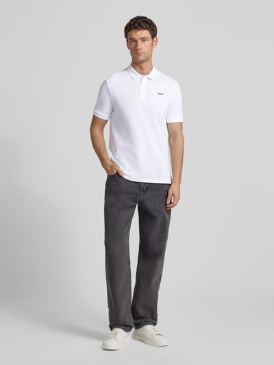 Männermodel trägt Regular Fit Poloshirt aus reiner Baumwolle Modell 'DONOS222' von HUGO, Optik: Unifarben, ganzkörperansicht von vorne.