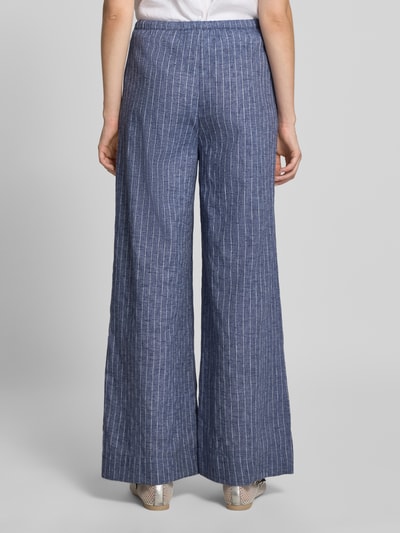 Frauenmodel trägt Wide Leg Hose mit Tunnelzug Modell 'HEIFA' von Neo Noir aus reiner Baumwolle, blau mit weißen Streifen, Ganzkörperansicht Rückansicht.
