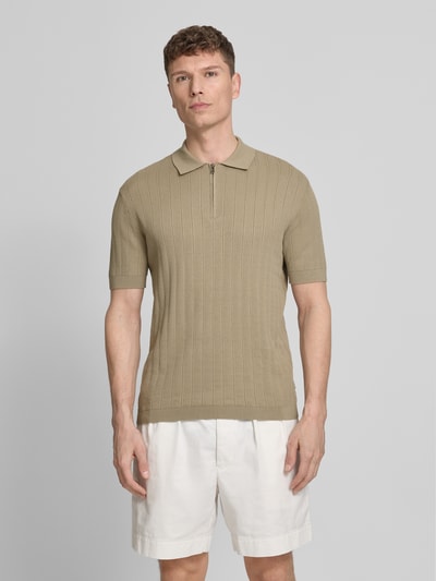 Męski model nosi Regular Fit Poloshirt mit Reißverschluss od ARMANI EXCHANGE, fakturowany wzór, krój regular fit, długość tyłu w rozmiarze M: 67 cm, zamek błyskawiczny, jasnobeżowy kolor, całkowity widok z przodu.