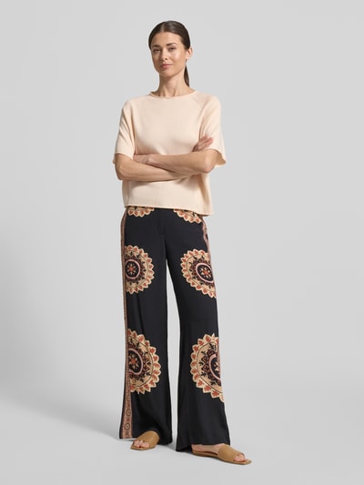 Vrouwenmodel draagt Relaxed Fit Pullover met kasjmier-aandeel model Moeny van Drykorn, katoenmix, tricotlook, halflange mouwen, ronde hals, ruglengte maat S 52 cm, mouwlengte maat S 23 cm, zachte perzikkleur, rechte vorm, glad oppervlak. Ganzkörperansicht van voren.