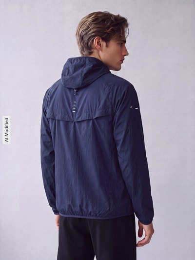 Männermodel trägt dunkelblaue Regular Fit Trainingsjacke aus reiner Baumwolle Modell 'STRIDE' von Nike, Herren Trainingsjacke, Ganzkörperansicht Rückansicht, KI-modifiziertes Bild.