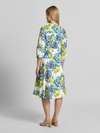 Modelka kobieca nosi Midikleid mit Tunikakragen und Knopfleiste von More & More, bawełna, linia A, wzór allover cytryny i granatowe kwiaty, rękaw 3/4, długość pleców w rozmiarze 36: 114 cm, szerokość w rozmiarze 36: 44 cm, długość rękawa w rozmiarze 36: 50 cm, widok całej sylwetki z tyłu