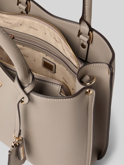 Produktfoto, Handtasche mit Label-Applikation Modell 'ECO MERIDIAN II' von Guess in Beige mit goldfarbenen Details, strukturierte Oberfläche, Reißverschluss, Tragehenkel und Schulterriemen, Innenfutter gemustert, Maße 33x23x11 cm, Länge Schulterriemen 106 cm.
