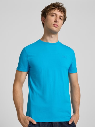 Männermodel trägt T-Shirt mit Rundhalsausschnitt und Label-Stitching von Superdry, reine Baumwolle, Slim Fit, leuchtend blau, Nahaufnahme Oberkörper.