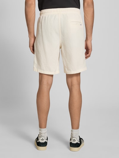 Männermodel trägt Shorts mit Strukturmuster Modell 'JAIDEN' von Jack & Jones, Material-Mix mit Baumwoll-Anteil, Regular-Fit, cremefarben, Bundweite bei Größe M 41 cm, Innenbeinlänge 21 cm, Ganzkörperansicht Rückansicht.