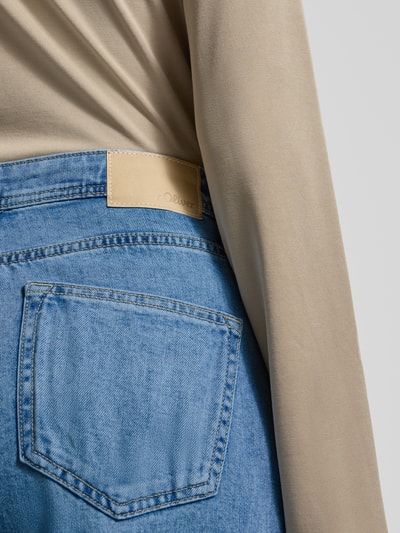 Vrouwenmodel draagt 'Wide Leg Jeans aus Baumwoll-Mix' van s.Oliver RED LABEL, denimlook, label patch, 5-pocket, detailopname rug.
