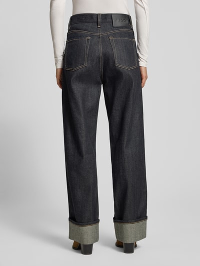 Frauenmodel trägt Wide Leg Jeans aus Baumwoll-Mix Modell 'GEABENA' von HUGO, Melange-Optik, Kontrastnähte, 5-Pocket-Design, Ganzkörperansicht Rückansicht.
