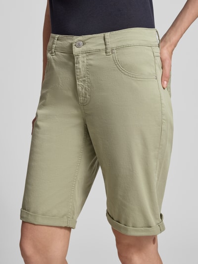 Frauenmodel trägt Bermudas mit Umschlag und Eingrifftaschen von Angels in hellem Grünton, Regular-Fit, Knopf-Reißverschluss, Nahaufnahme Oberkörper. Bundweite bei Größe 36: 40 cm, Innenbeinlänge: 25 cm.