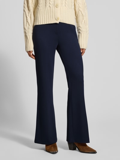Frauenmodel trägt Flared Cut Hose mit elastischem Bund von Christian Berg Woman in Dunkelblau, glatte Textur, Ganzkörperansicht von vorne, Material-Mix mit Viskose-Anteil, Gesäßtaschen, Bundweite 39 cm und Innenbeinlänge 82 cm bei Größe 36.