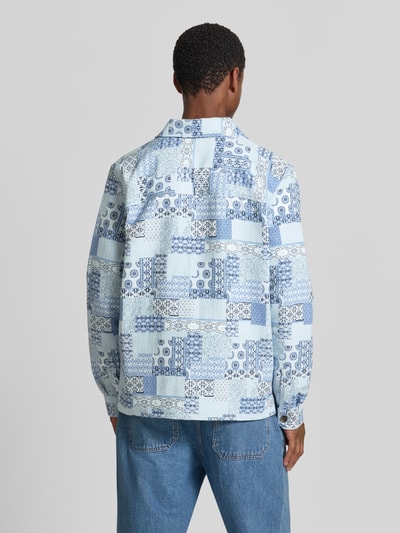 Męski model nosi Regular Fit Overshirt im Allover-Look von Les Deux, mieszanka bawełny, kołnierzyk typu kent, listwa guzikowa, długość tyłu w rozmiarze M: 69 cm, wzór na całej powierzchni w odcieniach niebieskiego, faktura gładka, widok całej sylwetki od tyłu.