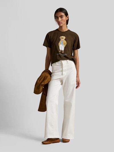 Frauenmodel trägt Regular Fit T-Shirt aus reiner Baumwolle von Polo Ralph Lauren, unifarben braun mit Motiv-Print, Ganzkörperansicht von vorne.