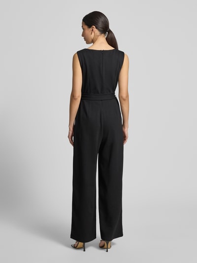 Vrouwenmodel draagt 'Jumpsuit uit viscosemix met strikceintuur' van Jake*s Collection, zwart, regular fit, binnenbeenlengte 80 cm, ruglengte 40 cm, borstwijdte 30 cm, totale lengte 150 cm, met stretch, ronde hals, viscosemix, strikceintuur, volledige lichaamsweergave achterkant.