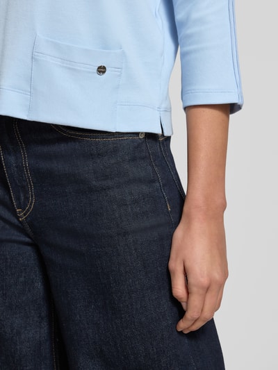 Vrouwenmodel draagt T-shirt met U-boot-hals en 3/4-mouw van Marc Cain, mix van katoen en elastaan, regular fit, detailopname onderlichaam.