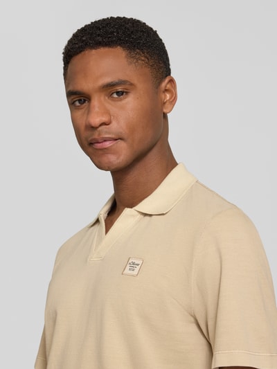 Männermodel trägt Regular Fit Poloshirt aus reiner Baumwolle von s.Oliver RED LABEL, Optik: Unifarben, Label-Patch, Nahaufnahme Oberkörper.