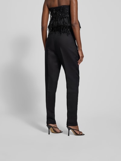 Frauenmodel trägt Stoffhose mit Bundfalten von black palms aus Lyocell-Mix mit Baumwoll-Anteil, lockerer Schnitt, Ganzkörperansicht Rückansicht.