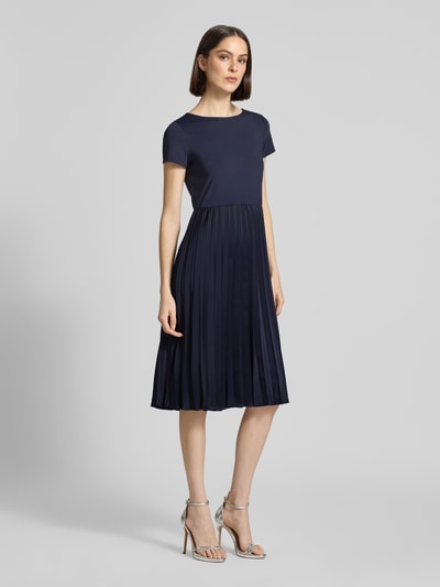 Frauenmodel trägt Midikleid in Plissee-Optik von Christian Berg Woman Selection, Dunkelblau, Elastischer-Material-Mix, Taillierte Passform, Rundhalsausschnitt, Kurzärmelig, Rückenlänge 108 cm, Brustweite 42 cm, Ärmellänge 15 cm, Ganzkörperansicht von vorne.