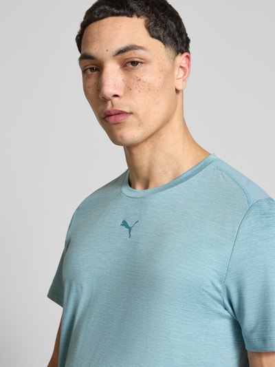 Mannenmodel draagt Regular Fit T-Shirt met logo-print model 'Cloudspun' van PUMA PERFORMANCE, ronde hals, blauw, detailopname bovenlichaam.