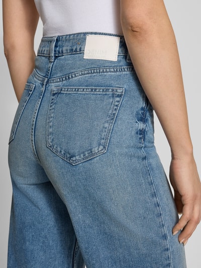 Frauenmodel trägt Wide Leg Jeans aus reiner Baumwolle Modell 'LINOU' von Tom Tailor Denim, hellblaue Denim-Optik, Label Patch, Nahaufnahme Rückansicht.