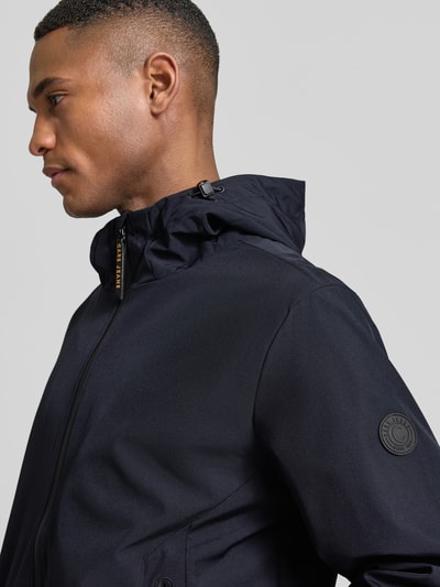 Männermodel trägt dunkelblaue Jacke mit Reißverschlusstaschen Modell 'MATTEO' von CARS JEANS, Material-Mix mit Stretch-Anteil, Nahaufnahme Oberkörper.