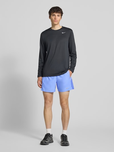 Männermodel trägt Shorts mit seitlichen Eingrifftaschen und Logo-Print von NIKE TRAINING, Loose-Fit, elastischer Bund, Ganzkörperansicht von vorne.