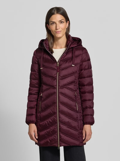 Modelka nosi Steppmantel mit Zweiwege-Reißverschluss von Christian Berg Woman Selection, krój slim fit, bordowy, z kapturem, przód, całopostaciowe ujęcie. Szerokość w rozmiarze 36: 48 cm, długość tyłu: 83 cm, szerokość ramion: 40 cm, długość rękawa: 65 cm.