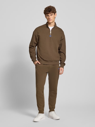 Męski model nosi Regular Fit Troyer aus reiner Baumwolle Modell 'NEELER' od Hugo Blue, jednolity brąz, dzianina, krój regular fit, zamek, długi rękaw, ściągacze, bawełna, widok całej sylwetki z przodu.