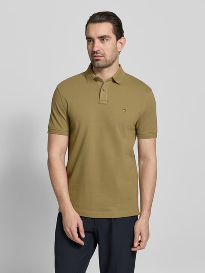 Männermodel trägt Regular Fit Poloshirt aus Baumwoll-Mix von Tommy Hilfiger, Optik: Unifarben, Logo-Stitching, kurzarm, Piqué, Ganzkörperansicht von vorne.