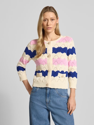 Frauenmodel trägt Strickjacke mit Knopfleiste und aufgesetzten Taschen von Rich & Royal in Creme, Pink und Blau aus reiner Baumwolle, Nahaufnahme Oberkörper.