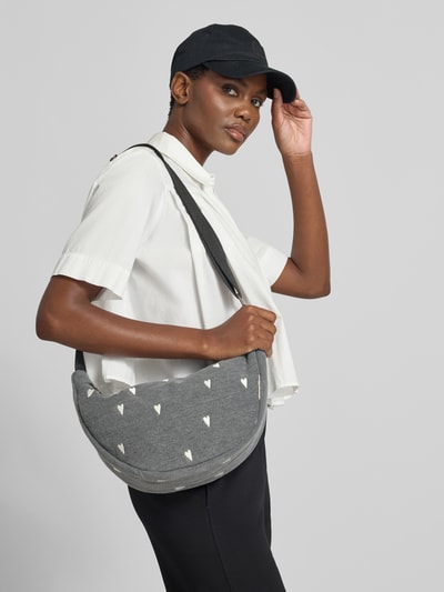 Frauenmodel trägt Fanny Pack aus reiner Baumwolle in tkanina stylizowana na denim von Studio Noos z wyhaftowanym motywem na całej powierzchni, detal z logo, Główna przegroda z zamkiem błyskawicznym, regulowany pasek na ramię, Szerokość w rozmiarze 1: 40 cm, Długość w rozmiarze 1: 21 cm, Głębokość w rozmiarze 1: 11 cm, Długość paska na ramię w rozmiarze 1: 118 cm, Ganzkörperansicht von vorne.