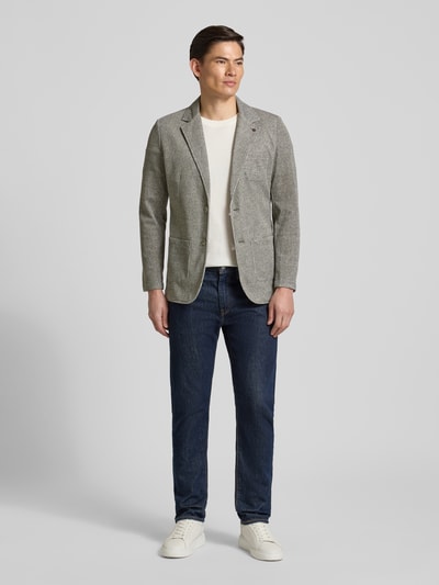 Męski model nosi Slim Fit 2-Knopf-Sakko mit Reverskragen von Zuitable, szary bawełniany blezer o strukturze, krój slim fit, przód, zdjęcie całopostaciowe.