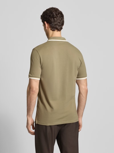 Männermodel trägt Slim Fit Poloshirt aus Bio-Baumwoll-Mix Modell 'SLIM ATLAS SPORT' von SELECTED HOMME, unifarben mit Kontraststreifen, Ganzkörperansicht Rückansicht