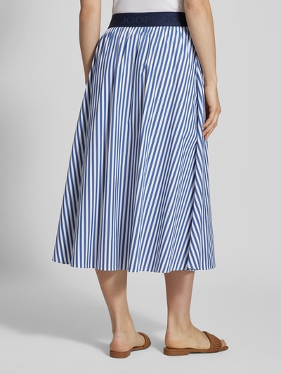 Vrouwenmodel draagt Regular Fit Midirock met elastische tailleband model 'Saskia' van JOOP!, blauw-wit gestreept, katoenmengsel, totale lengte 85 cm, taillewijdte 36 cm, achteraanzicht volledige lichaamsopname.