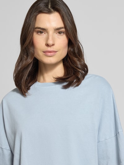 Vrouwenmodel draagt Boxy Fit T-Shirt met verlaagde schouders model 'KUSIA' van Drykorn, puur katoen, ronde hals, lichtblauw, detailopname bovenlichaam.