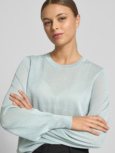 Frauenmodel trägt Regular Fit Pullover aus Viskose-Mix Modell 'Karta' von JOOP! mit Glitzer-Optik, elastische Ärmelabschlüsse, Trompetenärmel, Rundhalsausschnitt, zartes Hellblau, glatte Struktur, Nahaufnahme Oberkörper.
