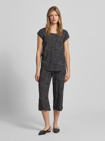Frauenmodel trägt Regular Fit Blusenshirt aus reiner Viskose Modell 'NOVA' von Only mit Allover-Muster, Kurzarm, Rundhals, Ganzkörperansicht von vorne.