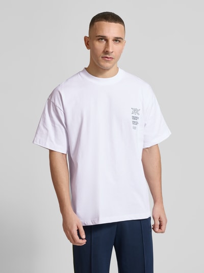 Męskimodel nosi t-shirt z nadrukiem z napisem model 'Athletic Department' od ANOTHER COTTON LAB, bawełna, prosty krój, okrągły dekolt, długość tyłu w rozmiarze M: 69 cm, widok z przodu na całe ciało.