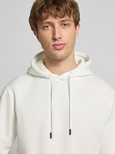 Männermodel trägt Hoodie mit Kapuze Modell 'BRADLEY' von Jack & Jones, Baumwoll-Mix, lockerer Schnitt, Nahaufnahme Oberkörper.