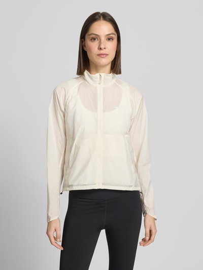 Frauenmodel trägt Regular Fit Jacke mit Stehkragen Modell 'Kout' von Salomon in Creme mit Reißverschluss und Eingrifftaschen, Ganzkörperansicht von vorne.