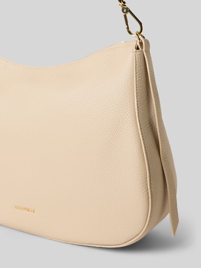 Produktfoto, Handtasche mit Label-Detail Modell 'NORY' von Coccinelle in Beige mit strukturierter Oberfläche, Hauptfach mit Reißverschluss, abnehmbarer Tragehenkel, Innenfach mit Reißverschluss, Maße 28x26x9 cm, Schulterriemen 109 cm