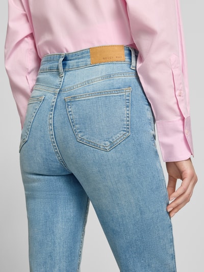 Frauenmodel trägt Flared Jeans mit 5-Pocket-Design Modell 'WENDIE' von Noisy May in hellblau, Baumwoll-Elasthan-Mix, Detailaufnahme Rückansicht.