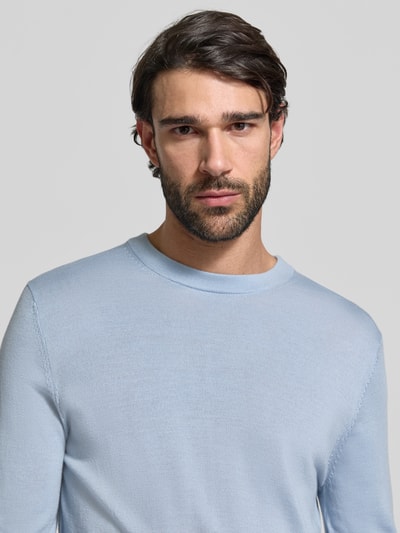 Männermodel trägt Regular Fit Pullover aus reiner Wolle Modell 'TRAY' von SELECTED HOMME in Hellblau, Feinstrickstruktur, Nahaufnahme Oberkörper.