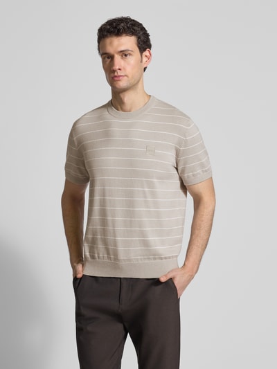 Mężczyzna nosi Regular Fit T-Shirt aus Baumwoll-Kaschmir-Mix Modell 'KANACHO' von BOSS Orange, beżowo-białe, w paski, dzianina, nakładka z logo, okrągły dekolt, krótkie rękawy, faktura gładka, widok na całe ciało z przodu.