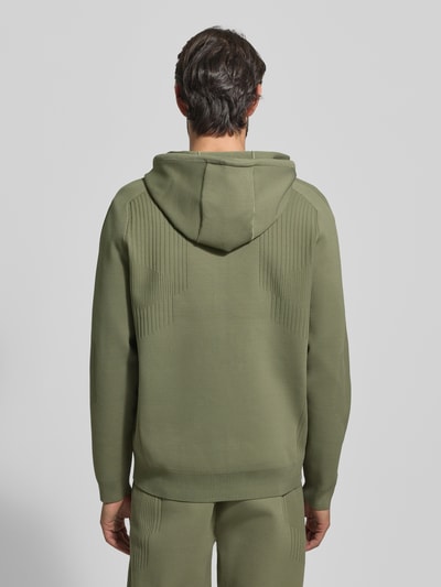 Männermodel draagt Regular Fit Trainingsjacke mit Jacquard Elementen Modell 'ACTIVE PUSH' van BOSS Green, olijfgroen, structuur, label-stitching, capuchon met trekkoord, geribde boorden, opgezette zakken, unikleurig, Ganzkörperansicht Rückansicht.