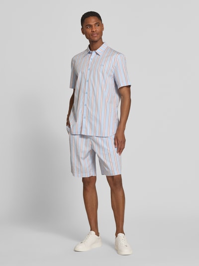 Męski model nosi Relaxed Fit Sweatshorts aus reiner Baumwolle od Lacoste, popelina, paski, elastyczny pas, logo, kieszenie; całe ciało z przodu.