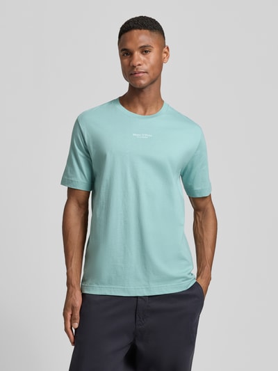 Männermodel trägt Regular Fit T-Shirt aus reiner Baumwolle von Marc O’Polo in Uni-Optik mit Label Print, Jerseystruktur, Ganzkörperansicht von vorne.