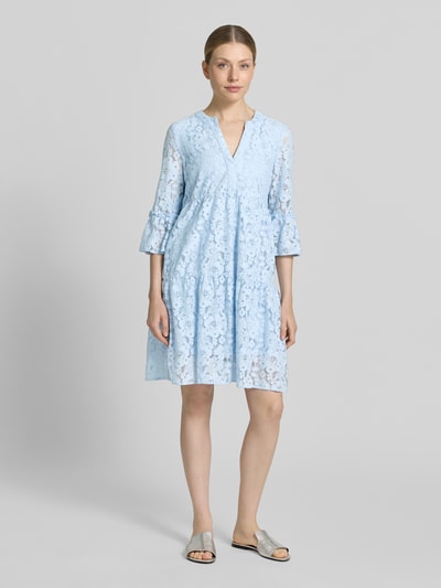 Frauenmodel trägt Loose Fit Spitzenkleid aus Baumwoll-Mix Modell 'HONEY' von Vero Moda, Optik: Unifarben, Muster: Spitzen-Muster, 3/4-Arm mit Glockenärmel, knielang, V-Ausschnitt, Materialverarbeitung: Spitze, sanftes Hellblau; Ganzkörperansicht von vorne.