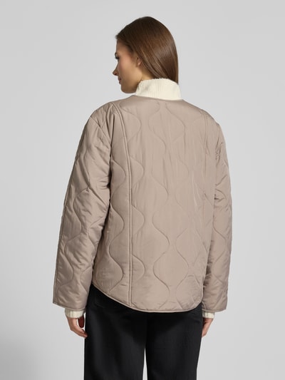 Vrouwenmodel draagt Regular Fit Steppjacke mit Pattentaschen Modell 'MILLIE' van Vero Moda in effen beige, gestepte textuur, zonder kraag, lange mouwen, knoopsluiting, Ganzkörperansicht Rückansicht.