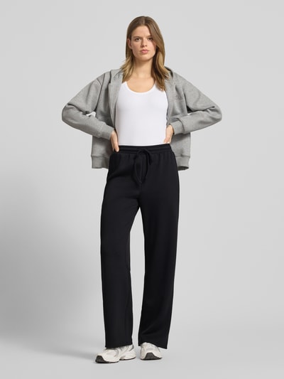 Frauenmodel trägt Regular Fit Sweatpants mit Viskose-Anteil Modell 'TALIA' von Pieces, unifarben schwarz, Sweat-Material, Ganzkörperansicht von vorne.