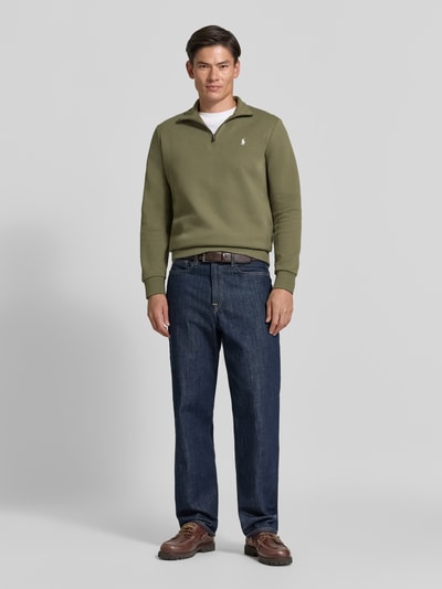 Mężczyzna nosi Regular Fit Troyer aus Baumwoll-Mix von Polo Ralph Lauren w kolorze oliwkowym, prosta faktura, Ganzkörperansicht von vorne.