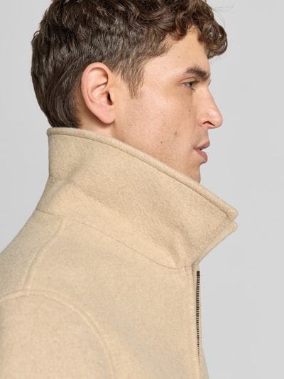 Männermodel trägt Blouson aus reiner Viskose von KENZO in Beige mit Zweiwege-Reißverschluss und Kontraststreifen, Nahaufnahme Oberkörper.